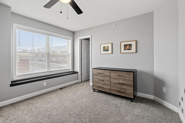 bedroom with light colored carpet, a textured ceiling, and ceiling fan