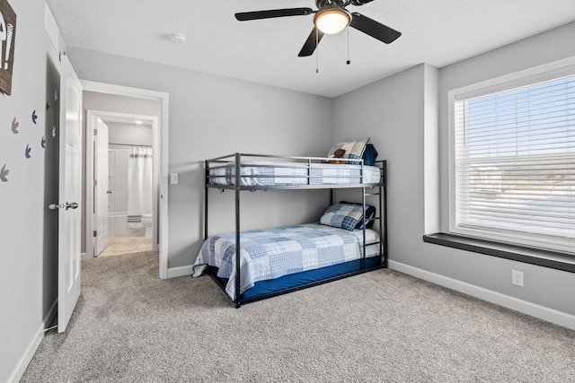 carpeted bedroom featuring ceiling fan and a textured ceiling