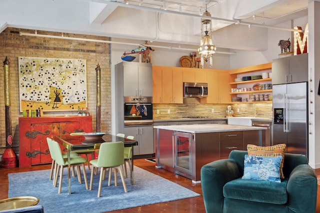 kitchen with a kitchen island, decorative light fixtures, wine cooler, stainless steel appliances, and decorative backsplash