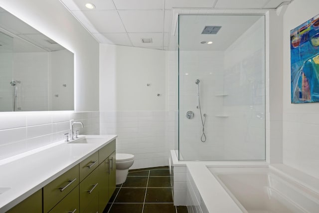 full bathroom featuring tile walls, vanity, tile patterned flooring, toilet, and separate shower and tub