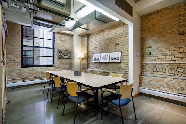 dining space featuring brick wall, a high ceiling, and a baseboard radiator