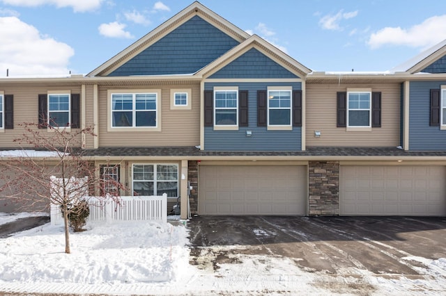 view of property featuring a garage and stone siding