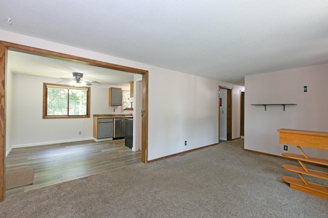 unfurnished living room featuring ceiling fan, carpet floors, and a textured ceiling