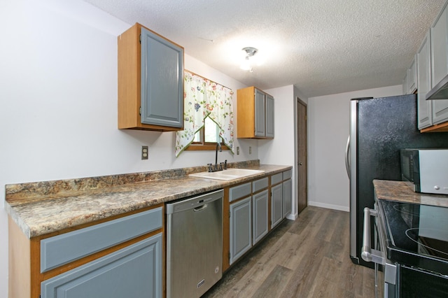 kitchen with dishwasher, a textured ceiling, dark hardwood / wood-style flooring, sink, and stove