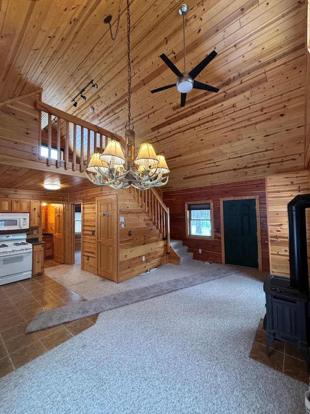 unfurnished living room with wooden ceiling, a wood stove, dark colored carpet, and high vaulted ceiling