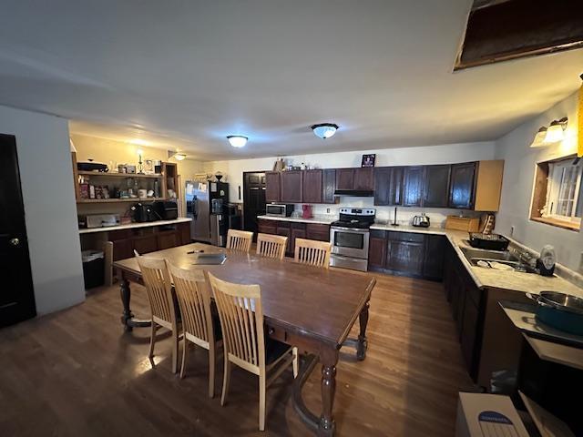 kitchen with dark hardwood / wood-style floors, dark brown cabinetry, and appliances with stainless steel finishes