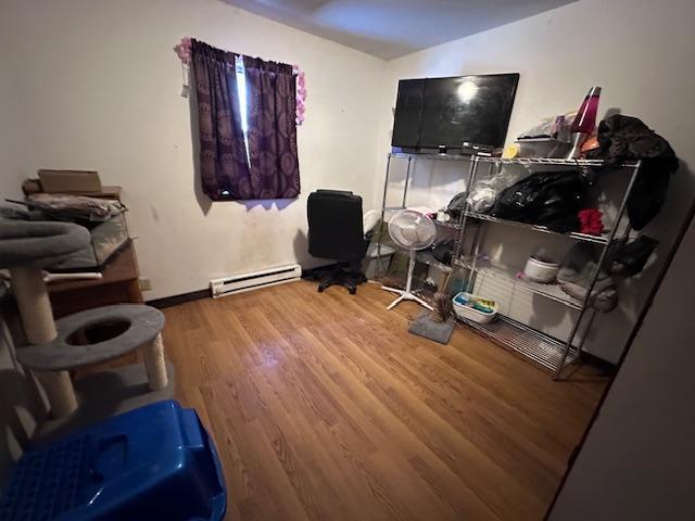 office area with hardwood / wood-style floors and a baseboard heating unit