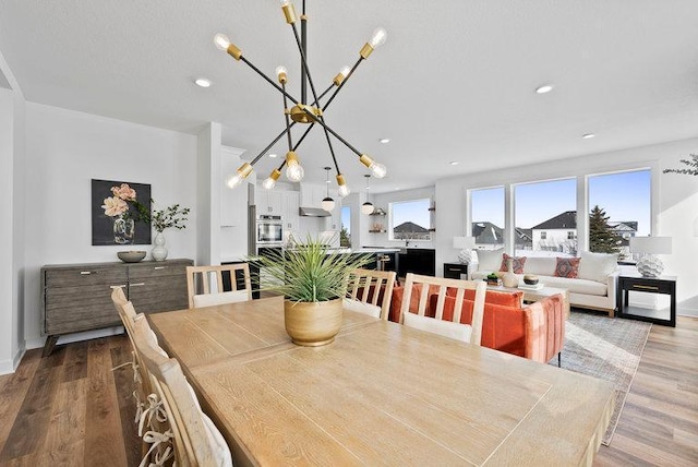 dining area with hardwood / wood-style floors and an inviting chandelier