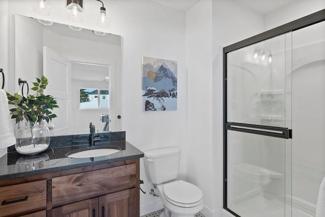 bathroom with a shower with door, vanity, and toilet