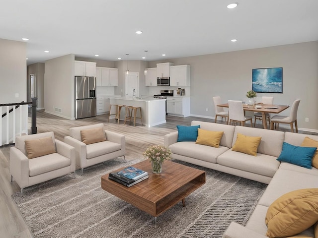 living room with sink and light wood-type flooring