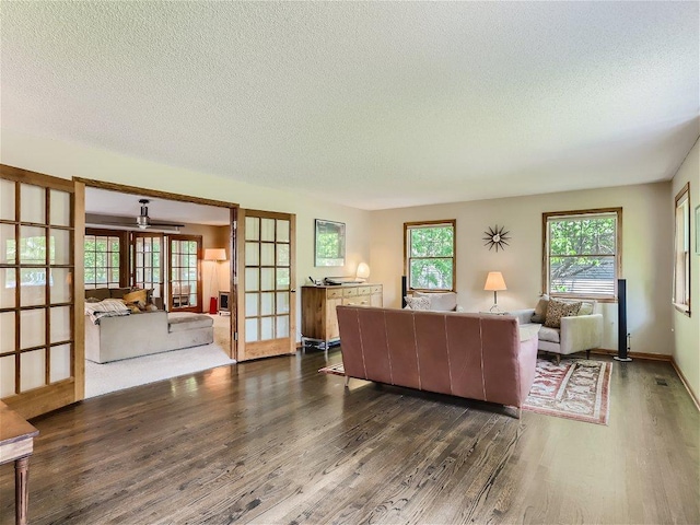 living room featuring french doors, dark wood-type flooring, and a textured ceiling