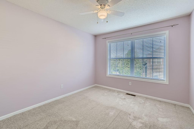 carpeted spare room with ceiling fan and a textured ceiling