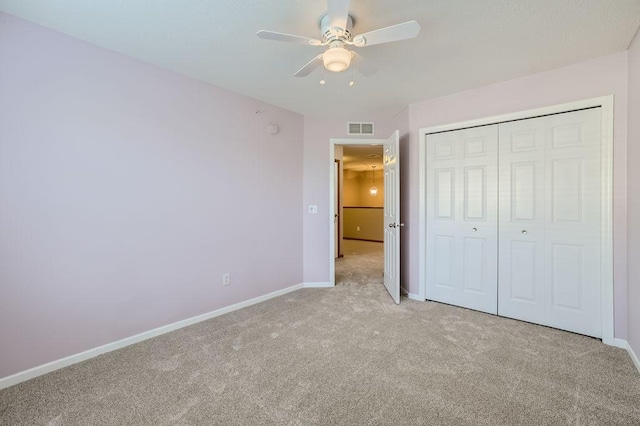 unfurnished bedroom with ceiling fan, a closet, and light colored carpet