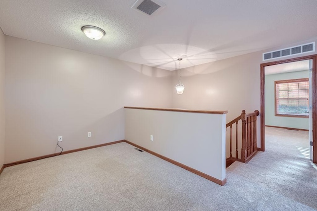 empty room with carpet and a textured ceiling