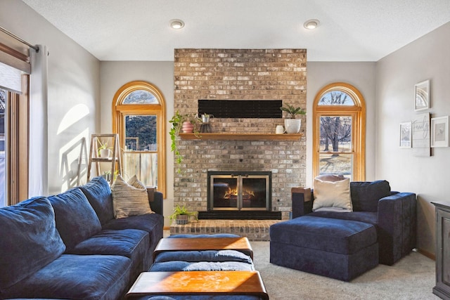 living room with a brick fireplace, a healthy amount of sunlight, and light colored carpet