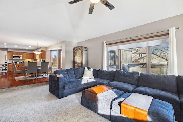 carpeted living room with lofted ceiling, a wealth of natural light, and ceiling fan