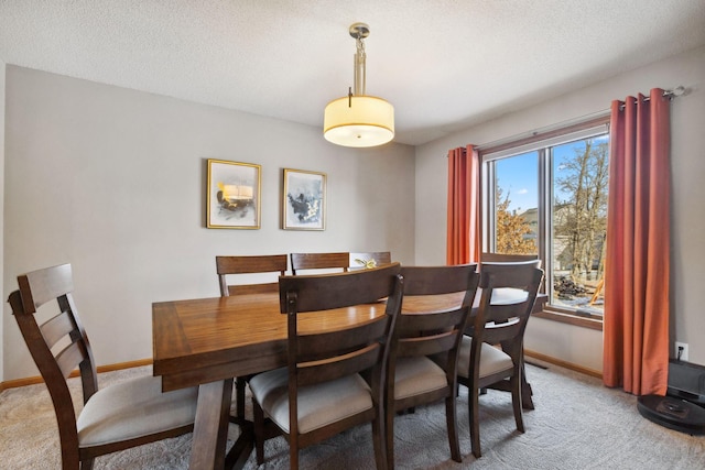 carpeted dining room featuring a textured ceiling