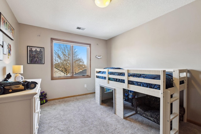 bedroom with light carpet and a textured ceiling