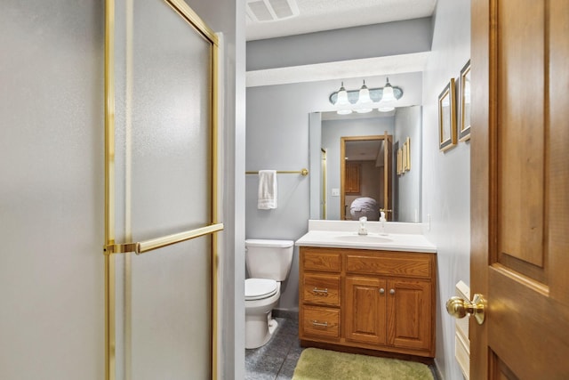 bathroom featuring vanity, an enclosed shower, and toilet