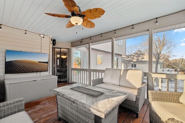 sunroom with ceiling fan, rail lighting, and a healthy amount of sunlight