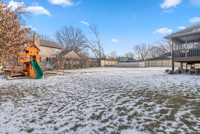 yard layered in snow featuring a playground, a sunroom, and a trampoline