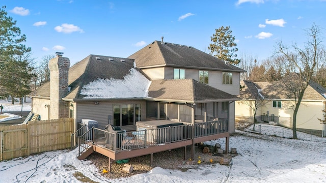 snow covered rear of property with a wooden deck