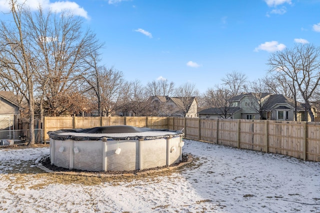 yard covered in snow with a covered pool