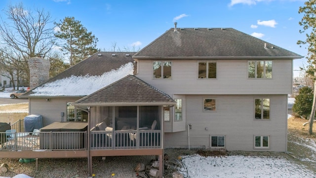 rear view of property with a sunroom and a deck