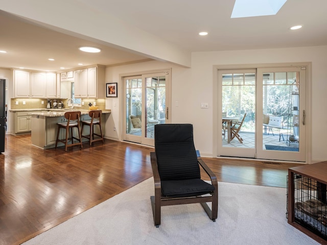 living area featuring a skylight and hardwood / wood-style flooring