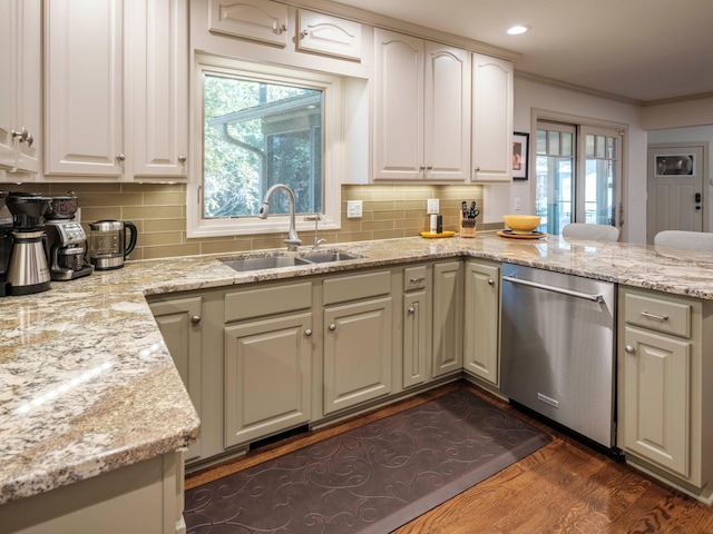 kitchen with light stone counters, stainless steel dishwasher, dark hardwood / wood-style floors, tasteful backsplash, and sink