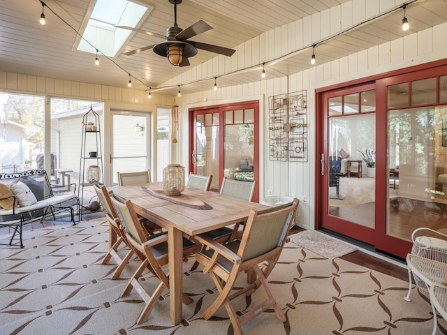 sunroom featuring ceiling fan, a skylight, and wooden ceiling