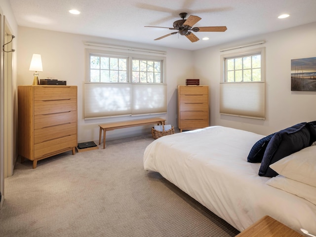 carpeted bedroom with ceiling fan and multiple windows