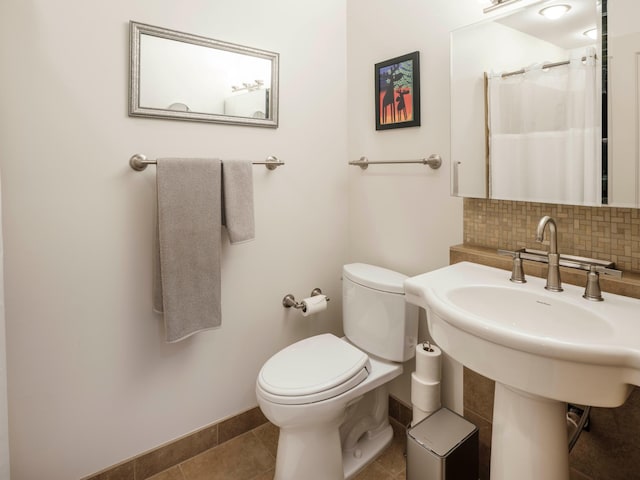 bathroom with toilet, a shower with shower curtain, tile patterned floors, sink, and tasteful backsplash