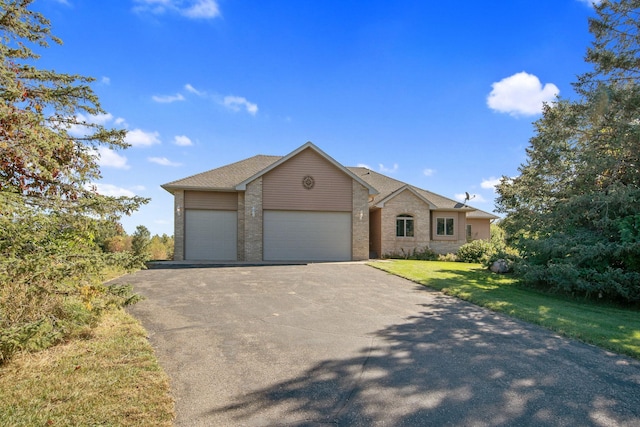 view of front of home with a front yard and a garage