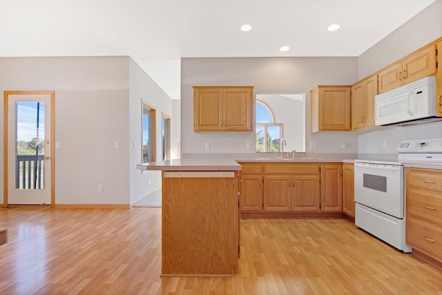 kitchen with light brown cabinets, stove, sink, light wood-type flooring, and a kitchen island