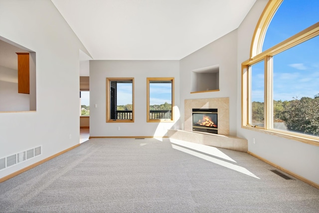 unfurnished living room with carpet and vaulted ceiling