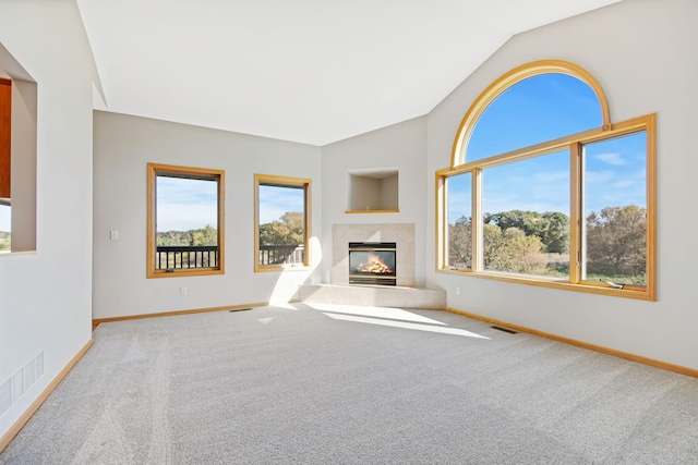 unfurnished living room featuring light colored carpet, lofted ceiling, and a fireplace