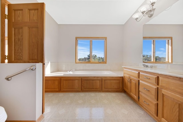 bathroom with a wealth of natural light, a washtub, and vanity