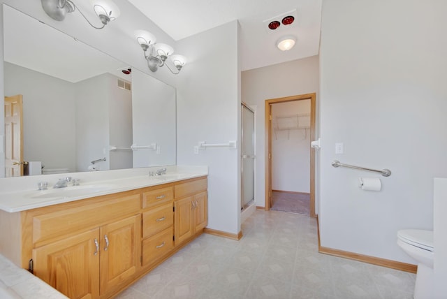 bathroom featuring vanity, toilet, and a shower with shower door