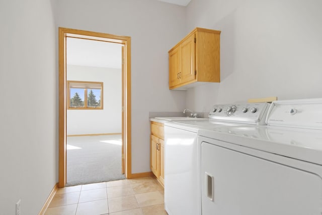 washroom with cabinets, sink, light tile patterned flooring, and washing machine and clothes dryer