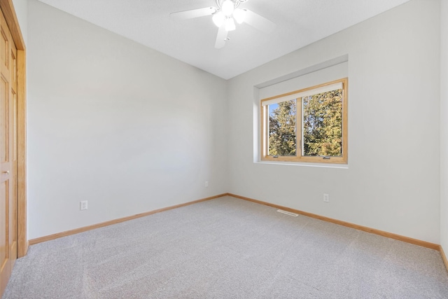 empty room with ceiling fan and carpet