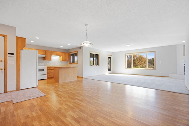 kitchen featuring light brown cabinets, white appliances, light wood-type flooring, a textured ceiling, and decorative light fixtures