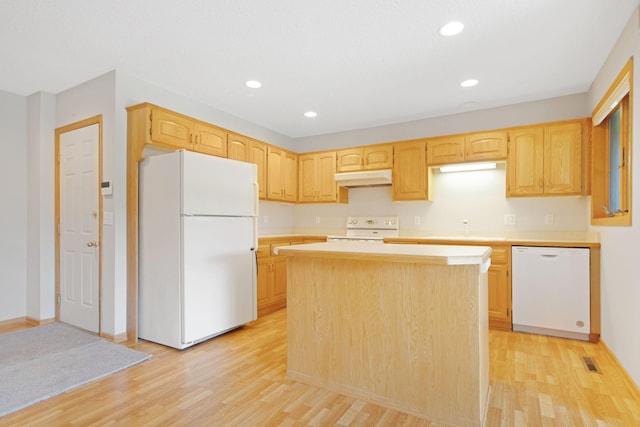 kitchen with light hardwood / wood-style floors, a kitchen island, white appliances, and light brown cabinets