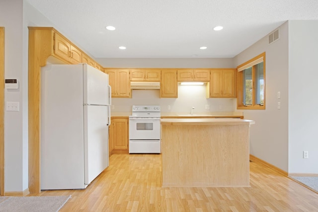 kitchen with light brown cabinetry, white appliances, and light hardwood / wood-style floors