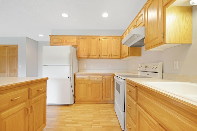 kitchen with white refrigerator, light wood-type flooring, range, and light brown cabinetry