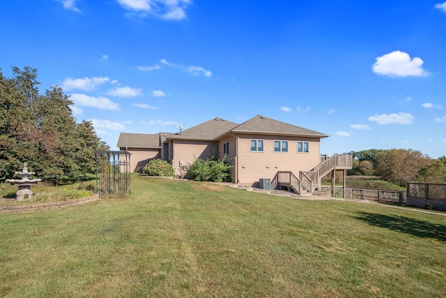 rear view of house featuring a lawn, a deck, and central air condition unit