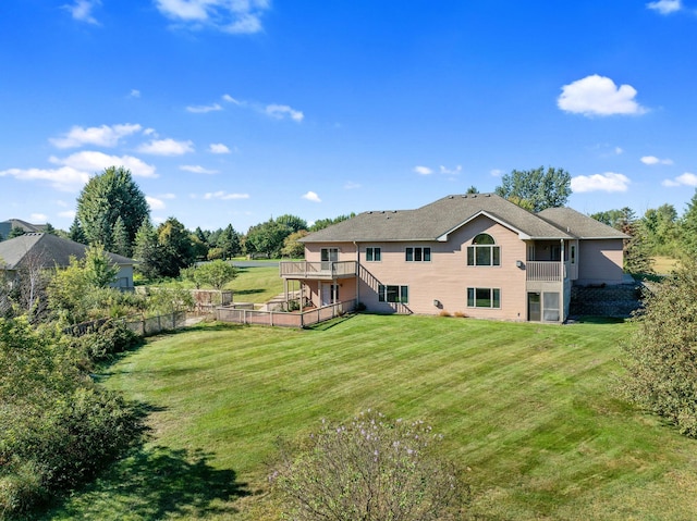 back of house featuring a lawn and a deck