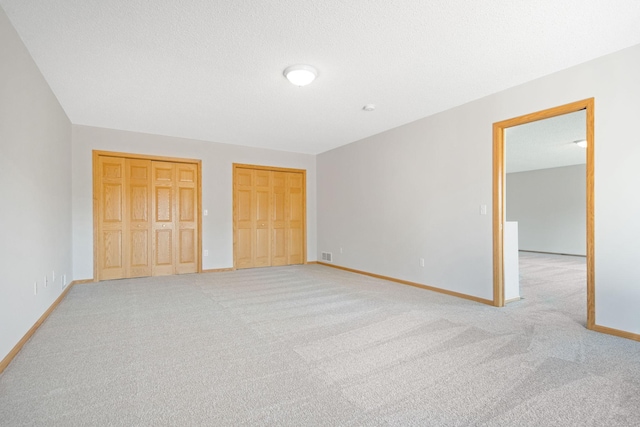 16377 Eidelweiss St NW, Andover, MN 55304 - unfurnished bedroom with visible vents, baseboards, two closets, and light carpet