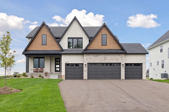 view of front facade featuring a front lawn, a porch, cooling unit, and a garage