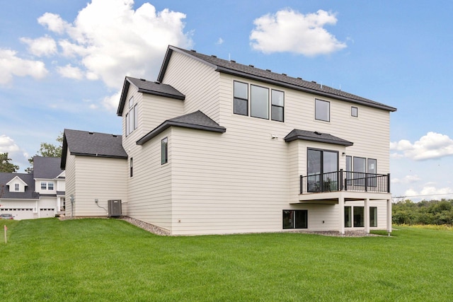 rear view of property with central air condition unit, a yard, and a balcony